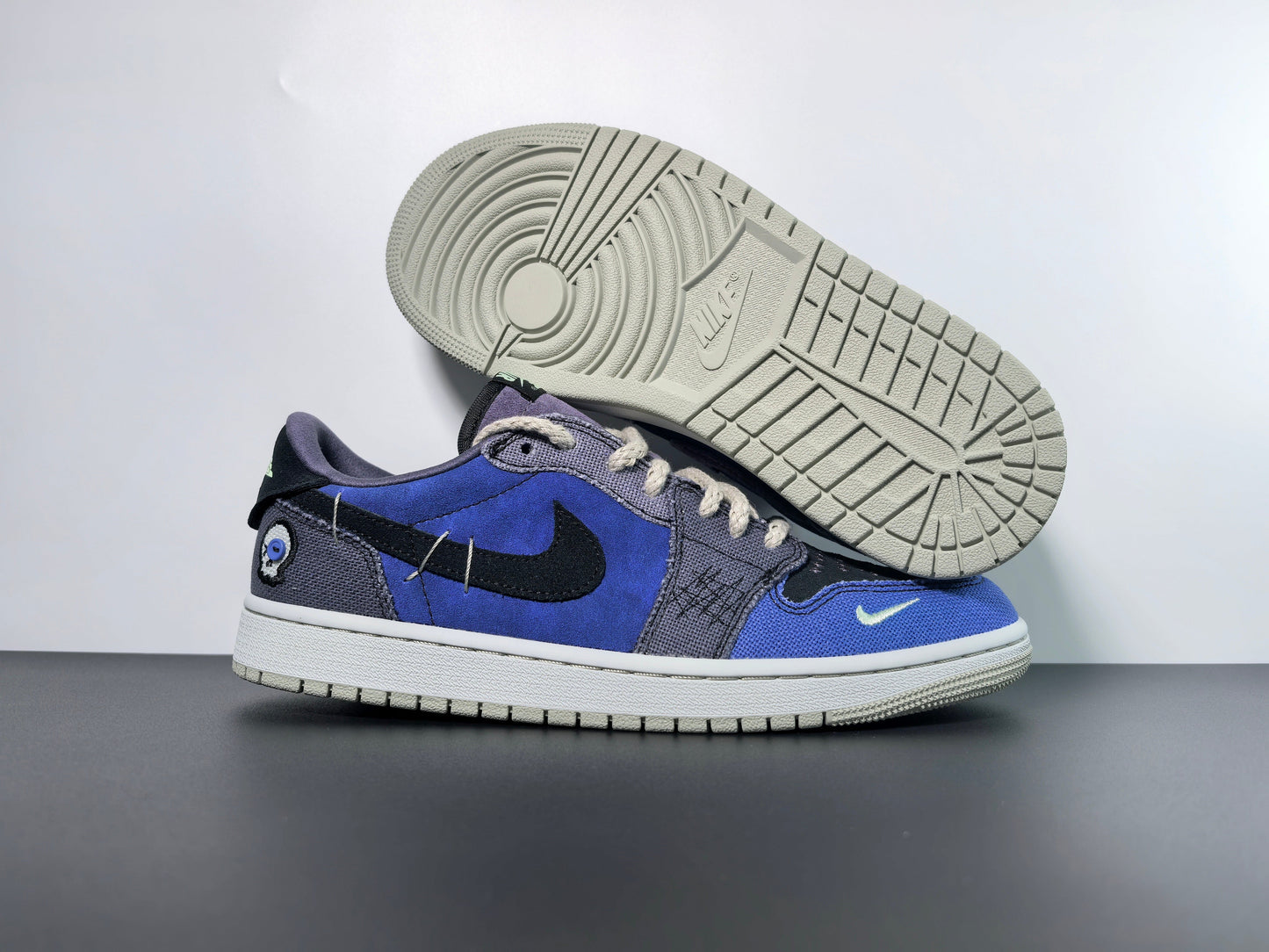 Premium blue and black designer sneaker with unique embroidered details, showcased on a stylish surface.