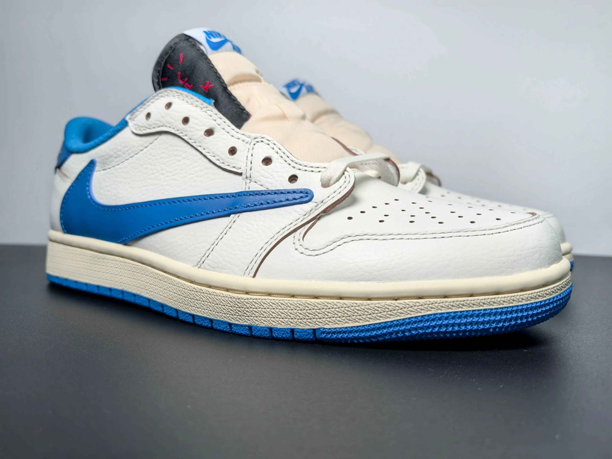Luxury urban wear white and blue low-top sneaker with premium leather, featured on dark surface