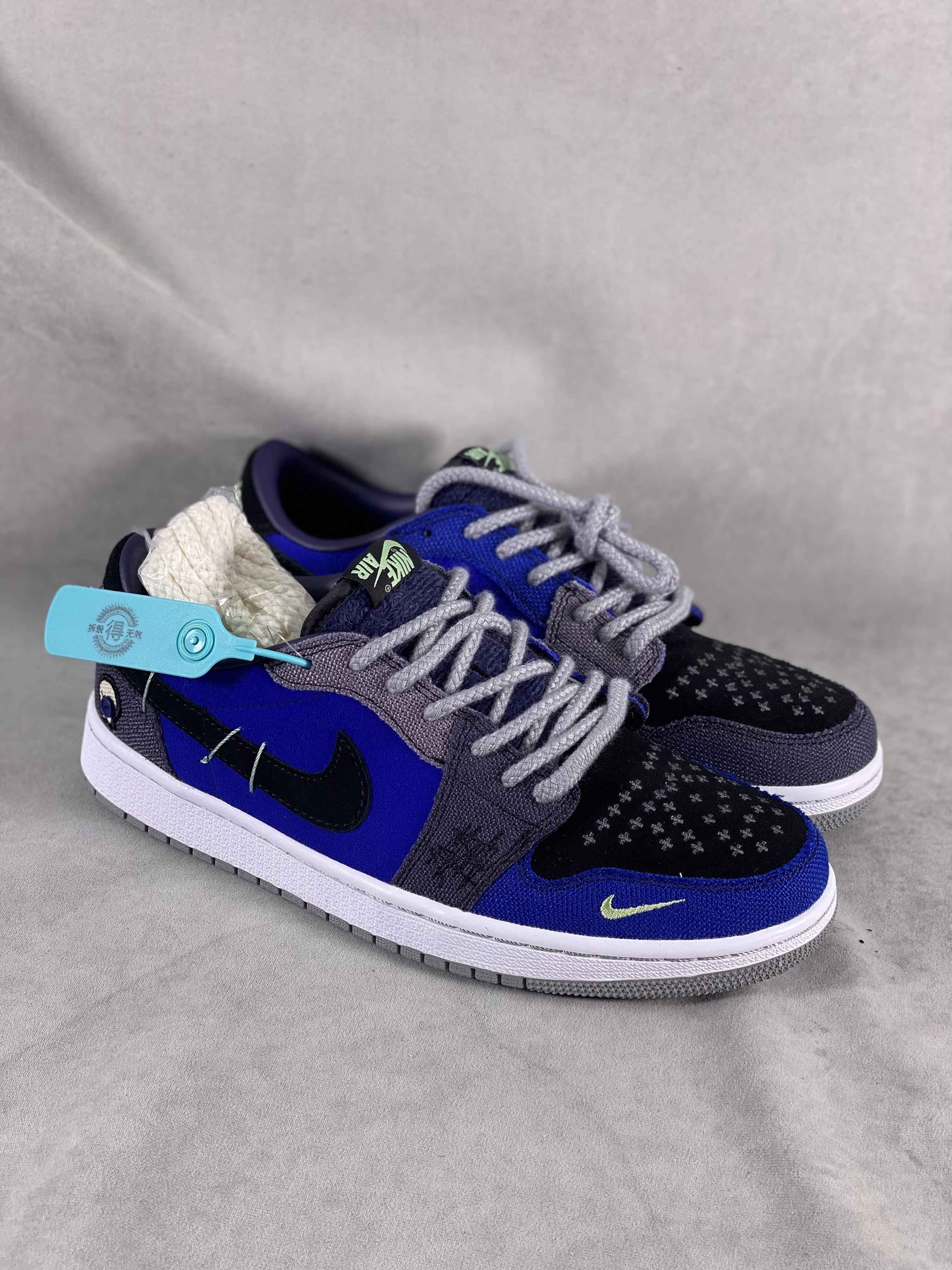 Luxury urban wear sneakers with blue, black, and grey design, displayed on a grey background.