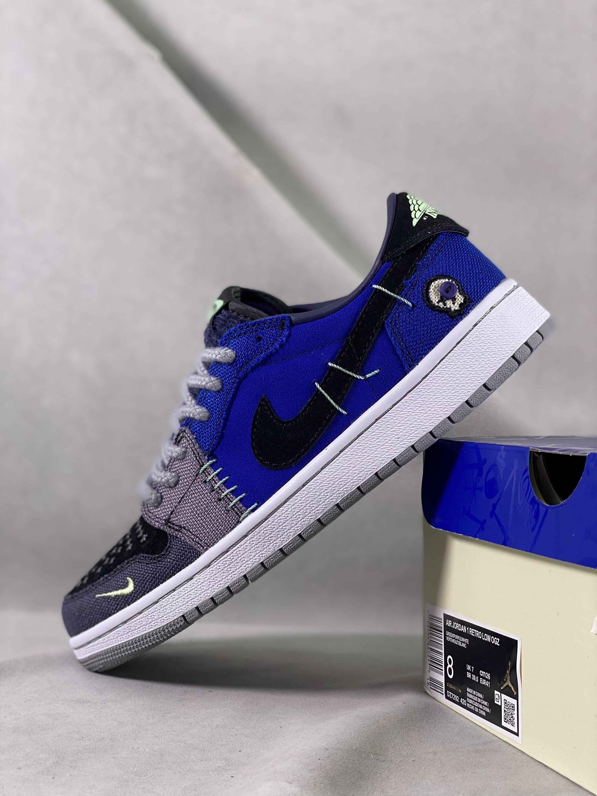 Luxuryurbanwear exclusive sneaker, Air Jordan 1 Low OG, blue and black designer streetwear shoe on display box.
